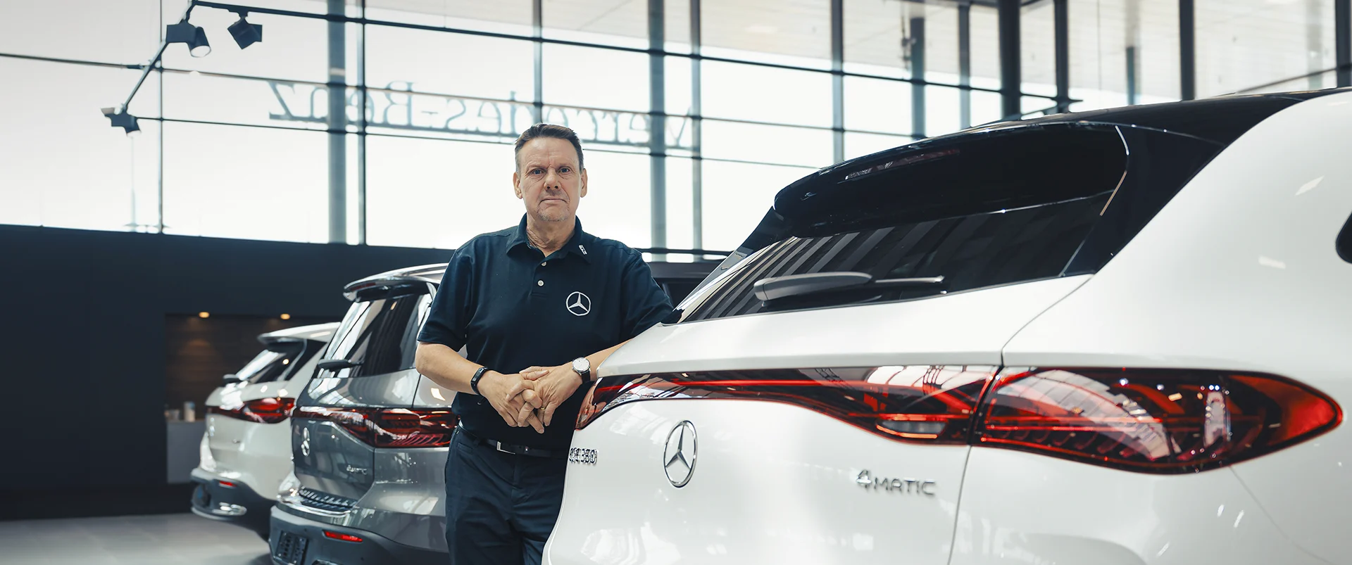 Pārdevējs pie Mercedes-Benz automašīnas salonā