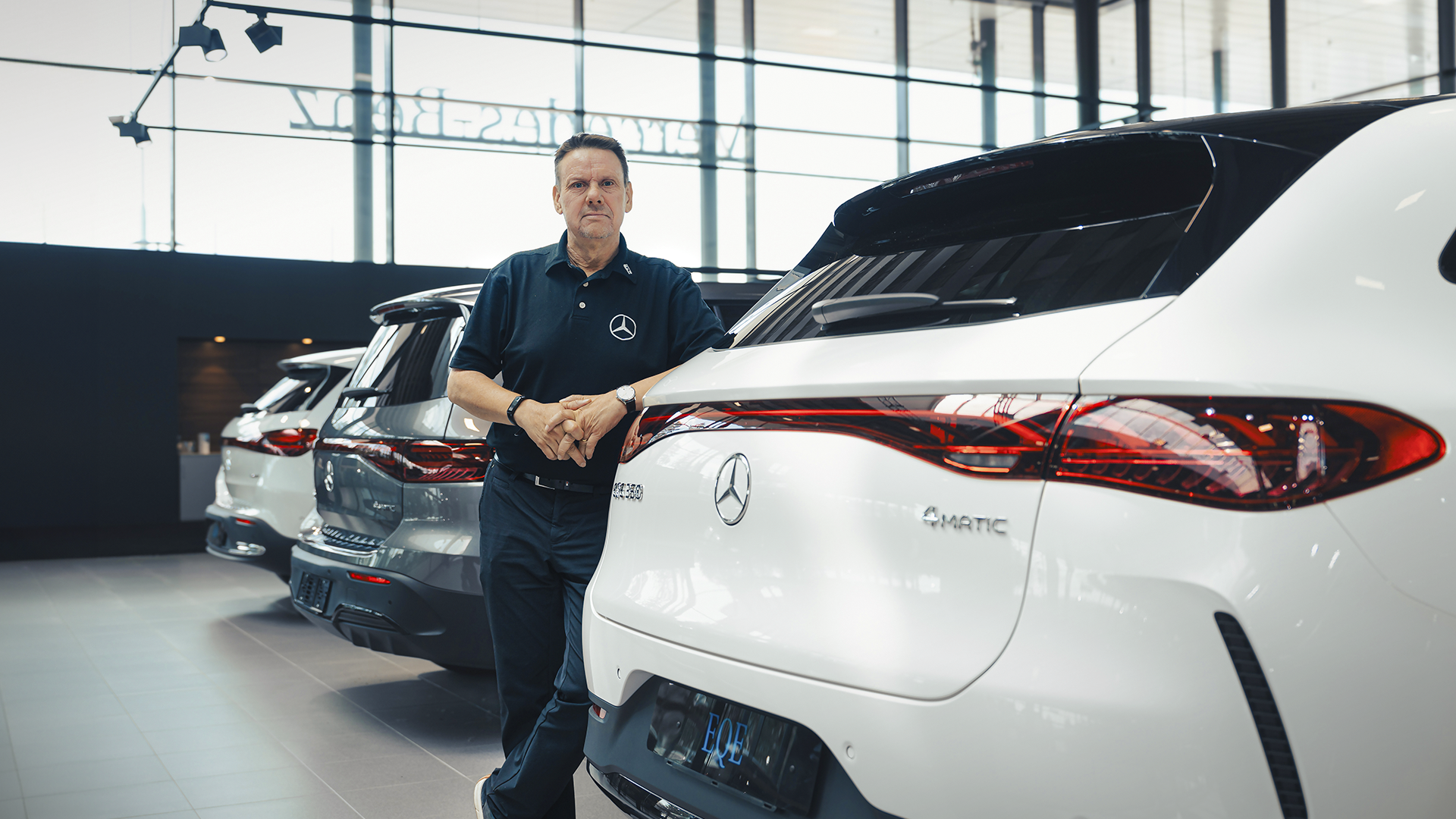 Pārdevējs pie Mercedes-Benz automašīnas salonā