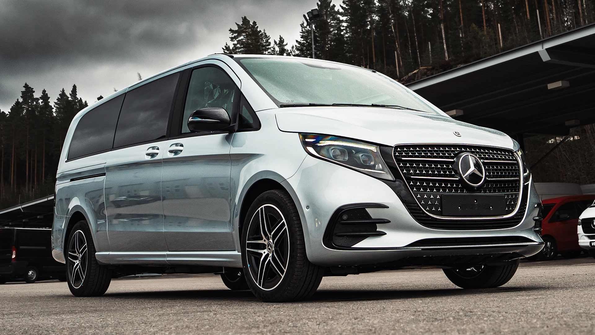 Mercedes-Benz V klase minivens ēkas priekšā.