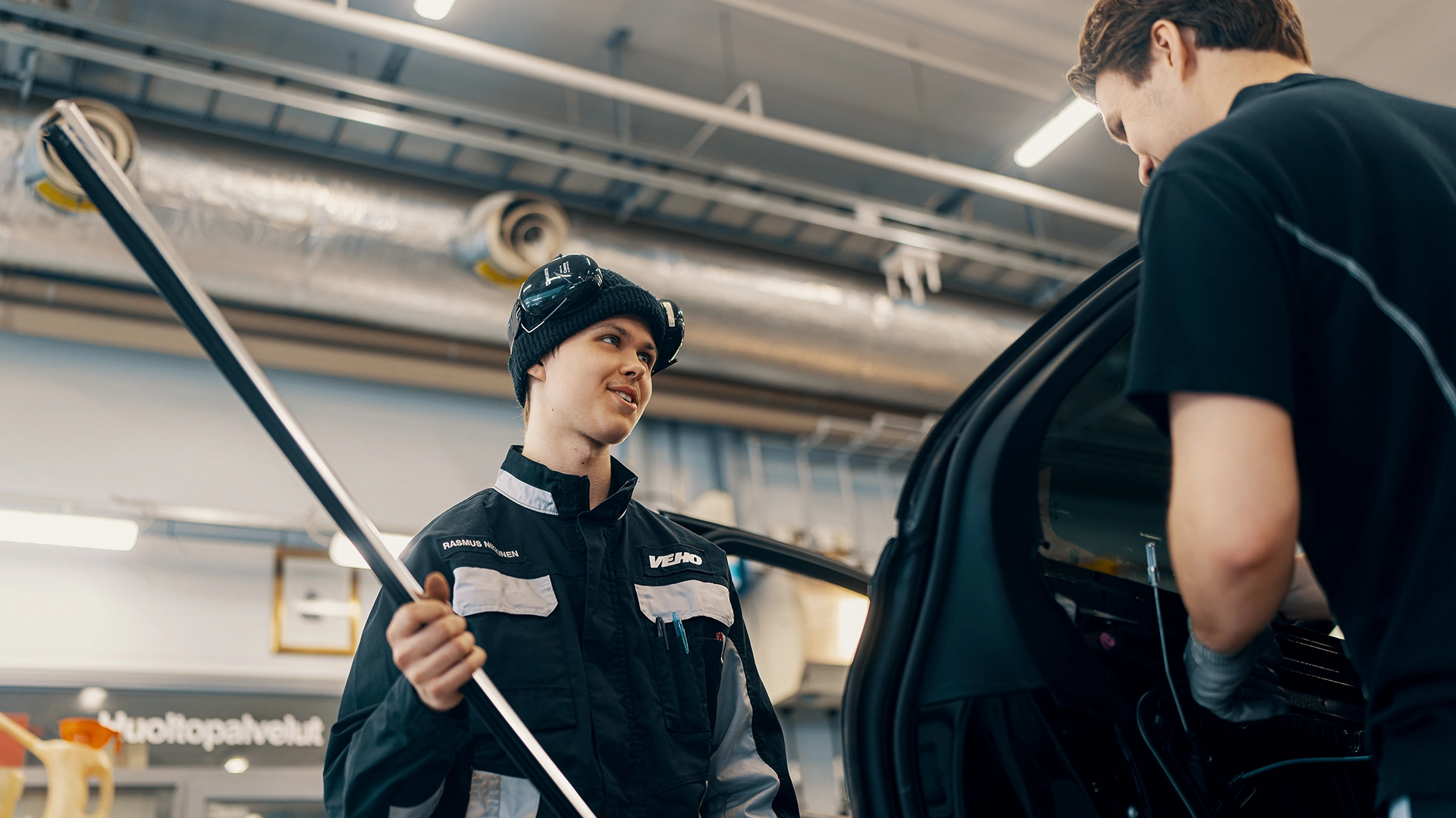 Jauns vīrietis auto mehāniķis Veho servisa centra tehniskajā zālē