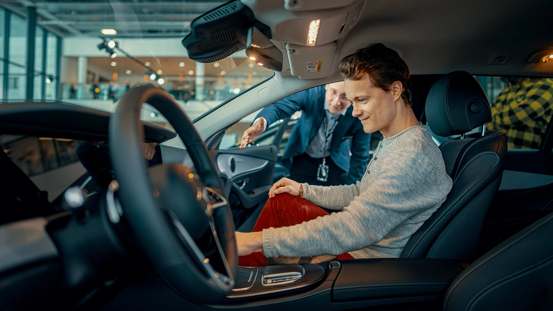 Veho auto pārdevējs salonā rāda jaunu Mercedes-Benz automašīnu