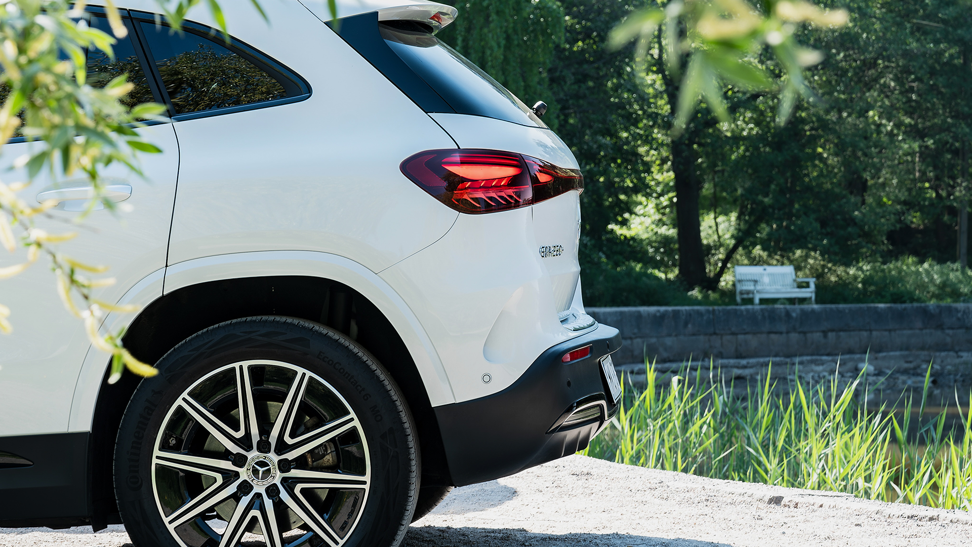 Mercedes-Benz EQA aizmugurējais sāns uz vasarīga fona