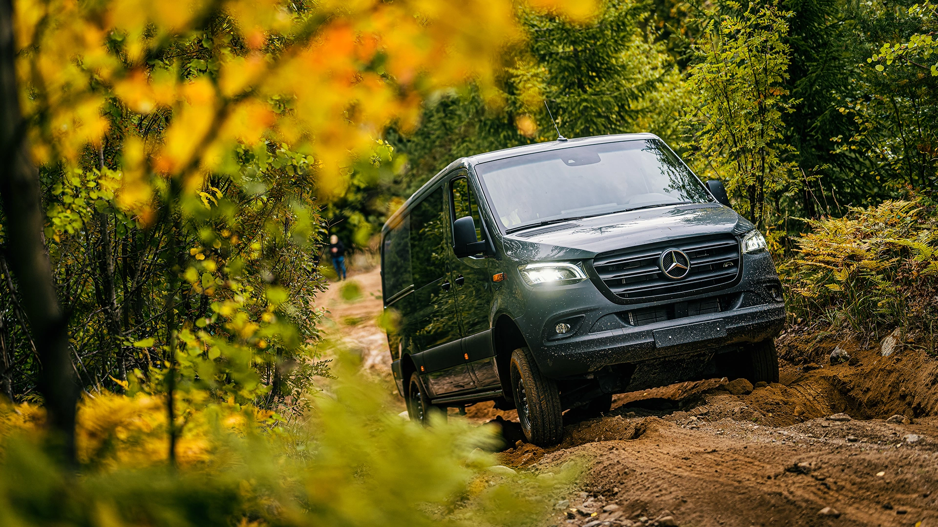 Mercedes-Benz Sprinter brauc pa meža ceļu rudenī