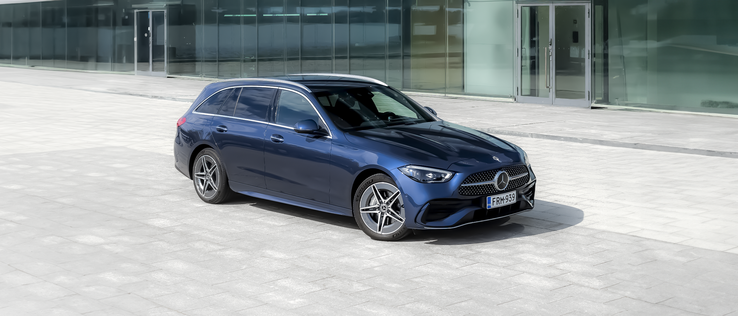 Mercedes-Benz C-klase biroju ēkas priekšā