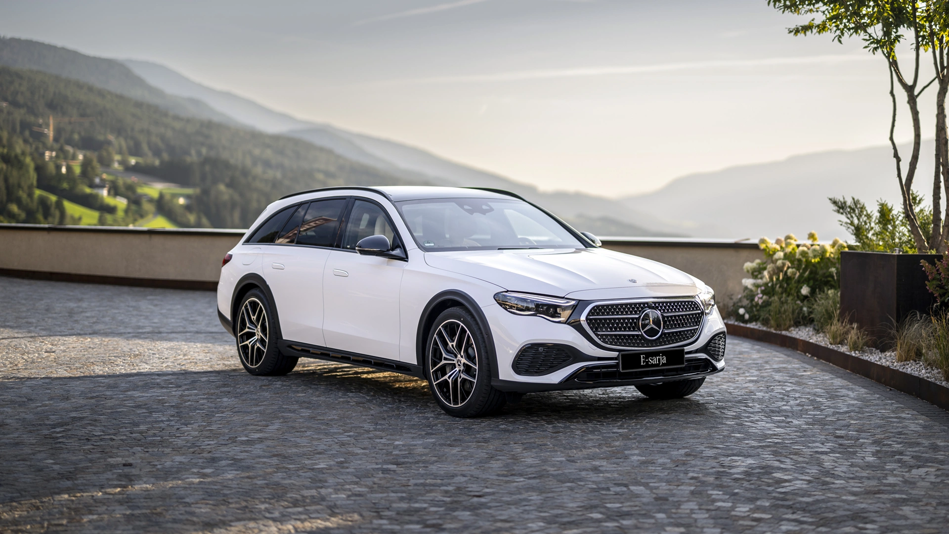 Mercedes-Benz E-klase stāvvietā uz kalnu fona