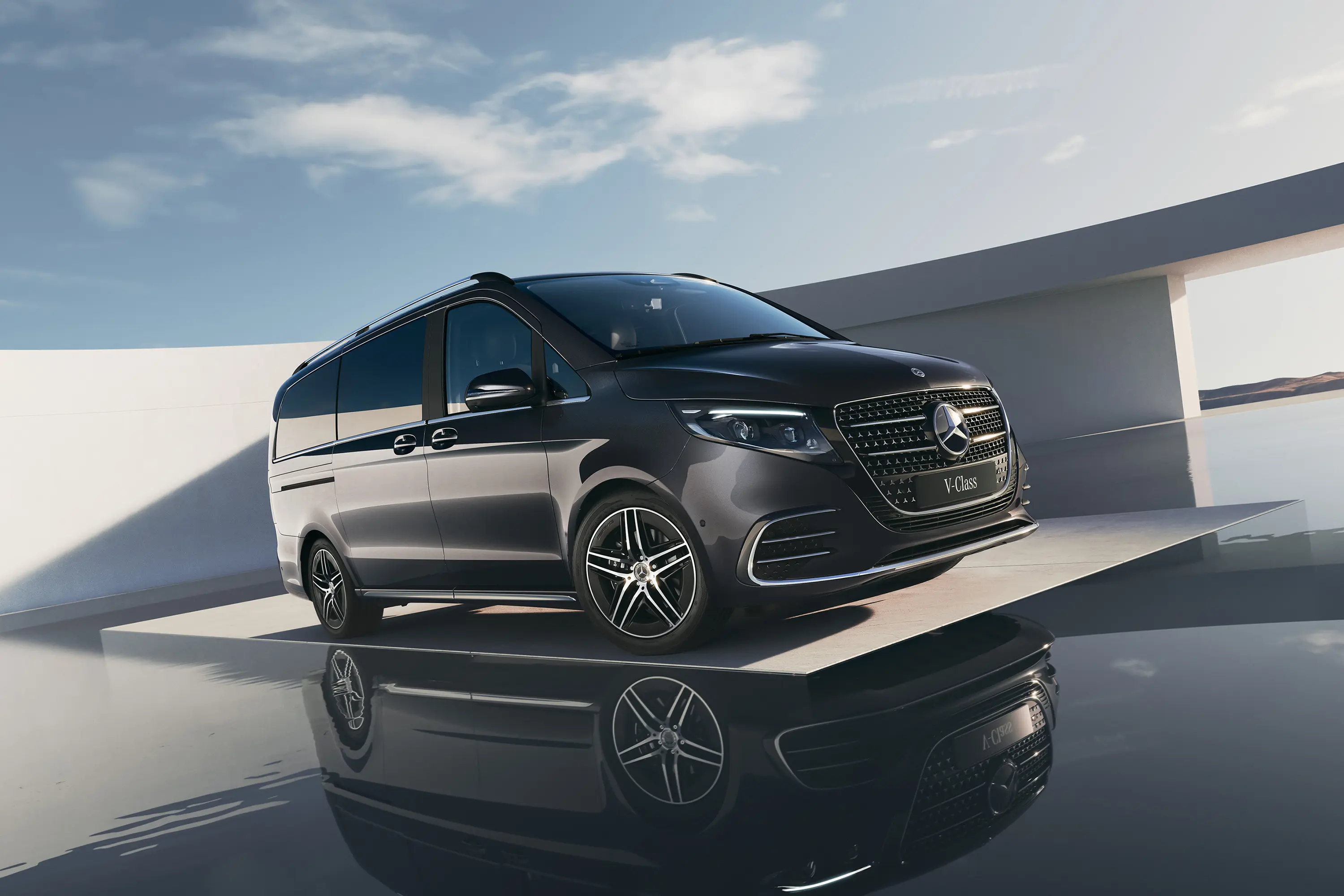 Mercedes-Benz V-klase melnā krāsā uz debesu fona