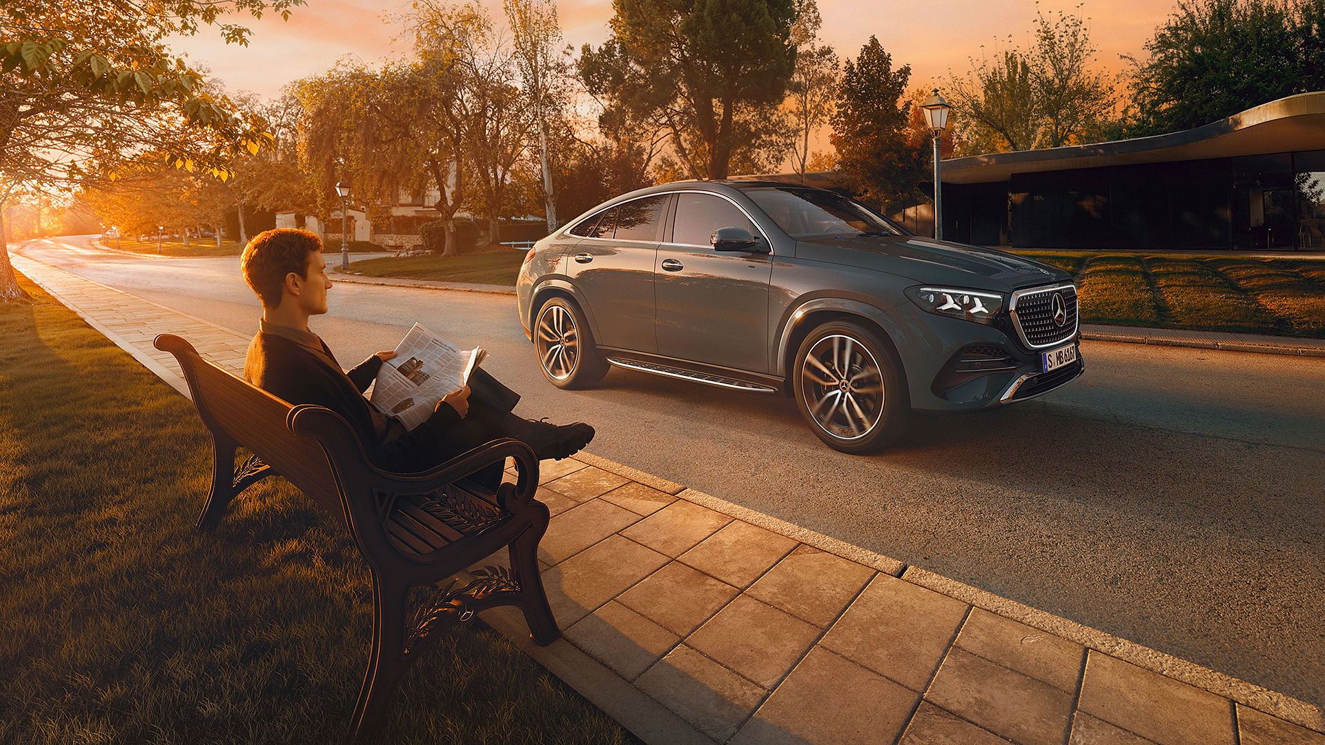 Mercedes-Benz GLE Coupé novietots rudenīgā ainavā, priekšplānā vīrietis lasa grāmatu