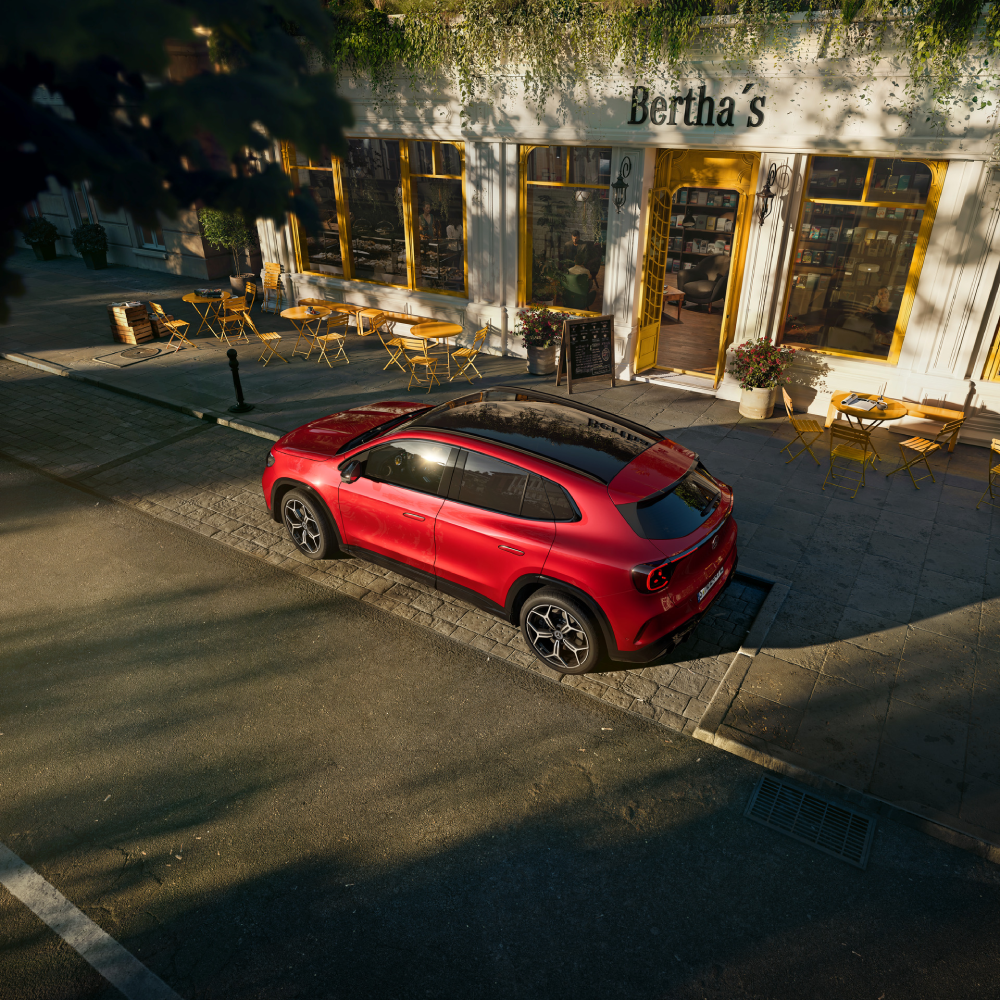 Sarkanā GLA pie kafejnīcas – "Pilnībā elektriskais Mercedes-Benz GLA pilsētas ielā pie kafejnīcas"