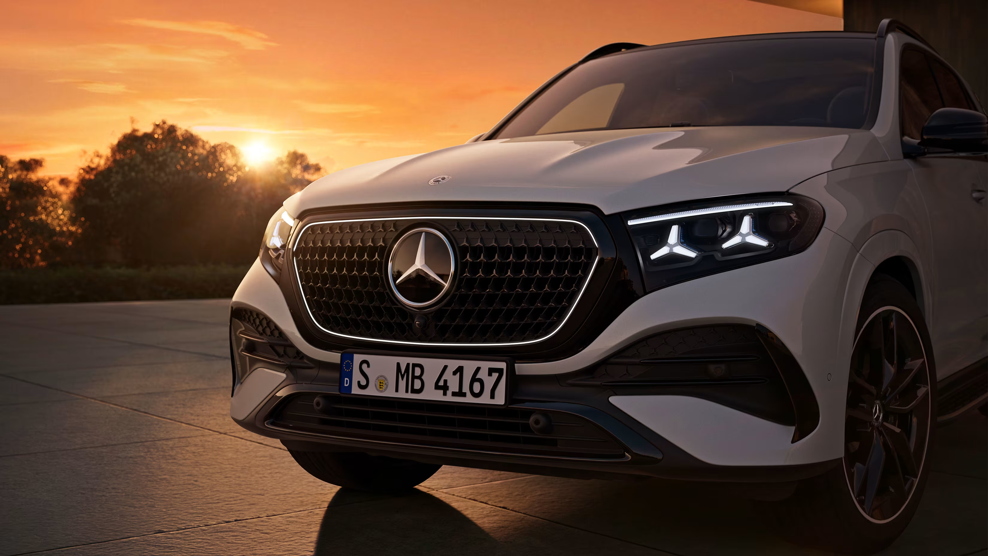 Mercedes-Benz GLE priekšdaļa ar radiatora režģi un zvaigznes logotipu saulrietā